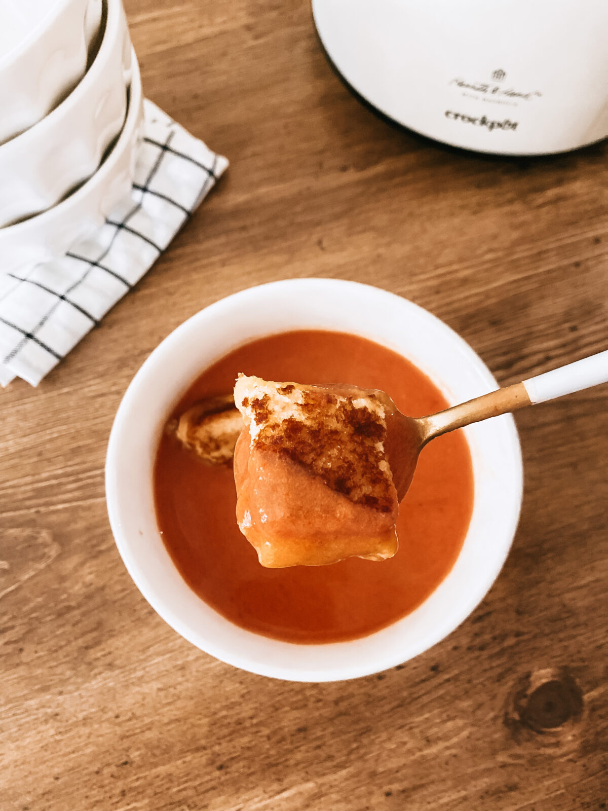 homemade tomato soup with grilled cheese croutons on wooden table
